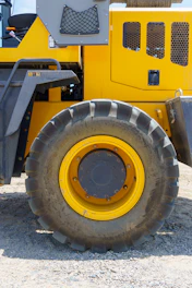 Heavy-duty civil engineering tire on a construction site with dirt and machinery