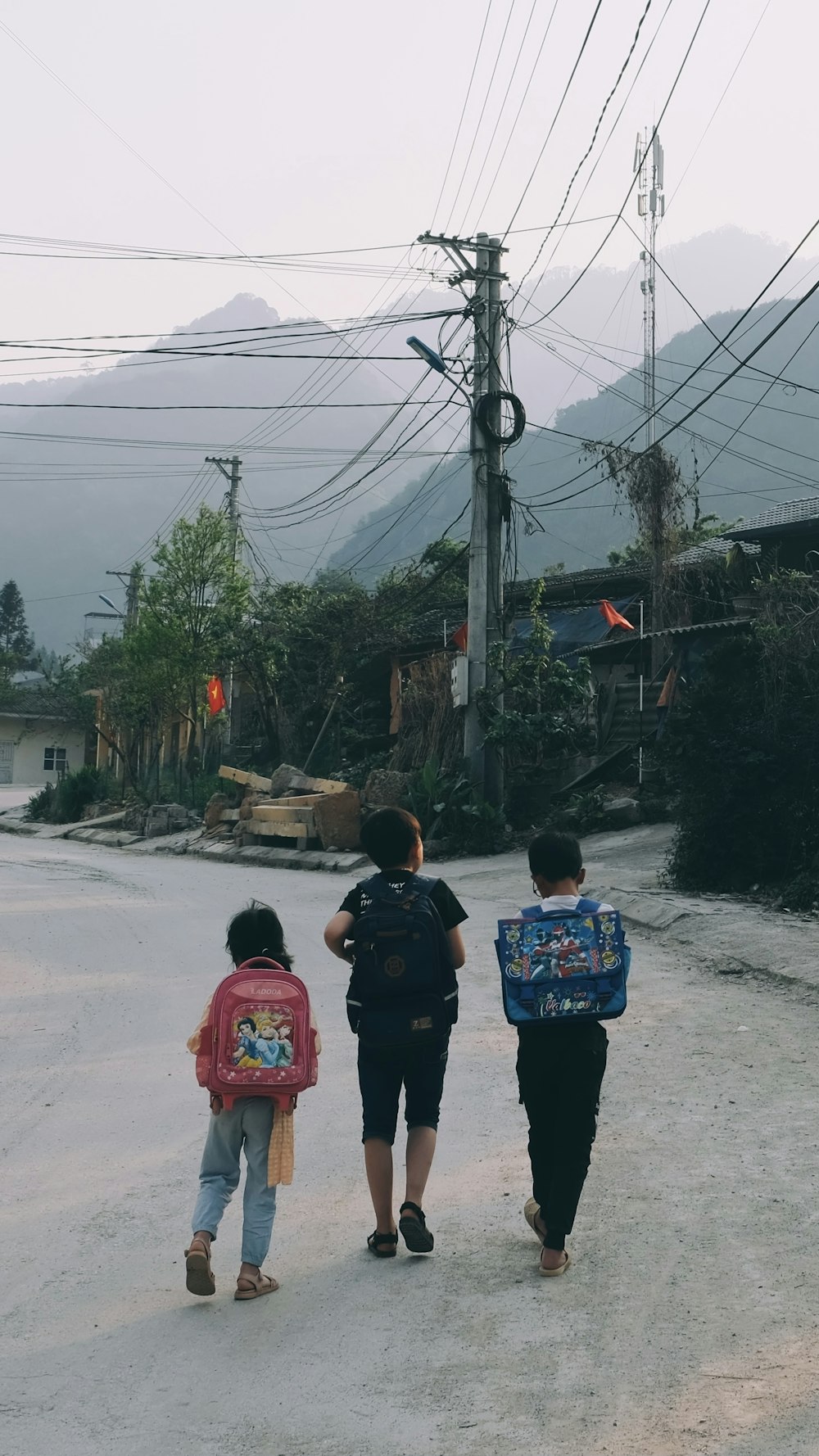 a group of people walking on a road with power lines above