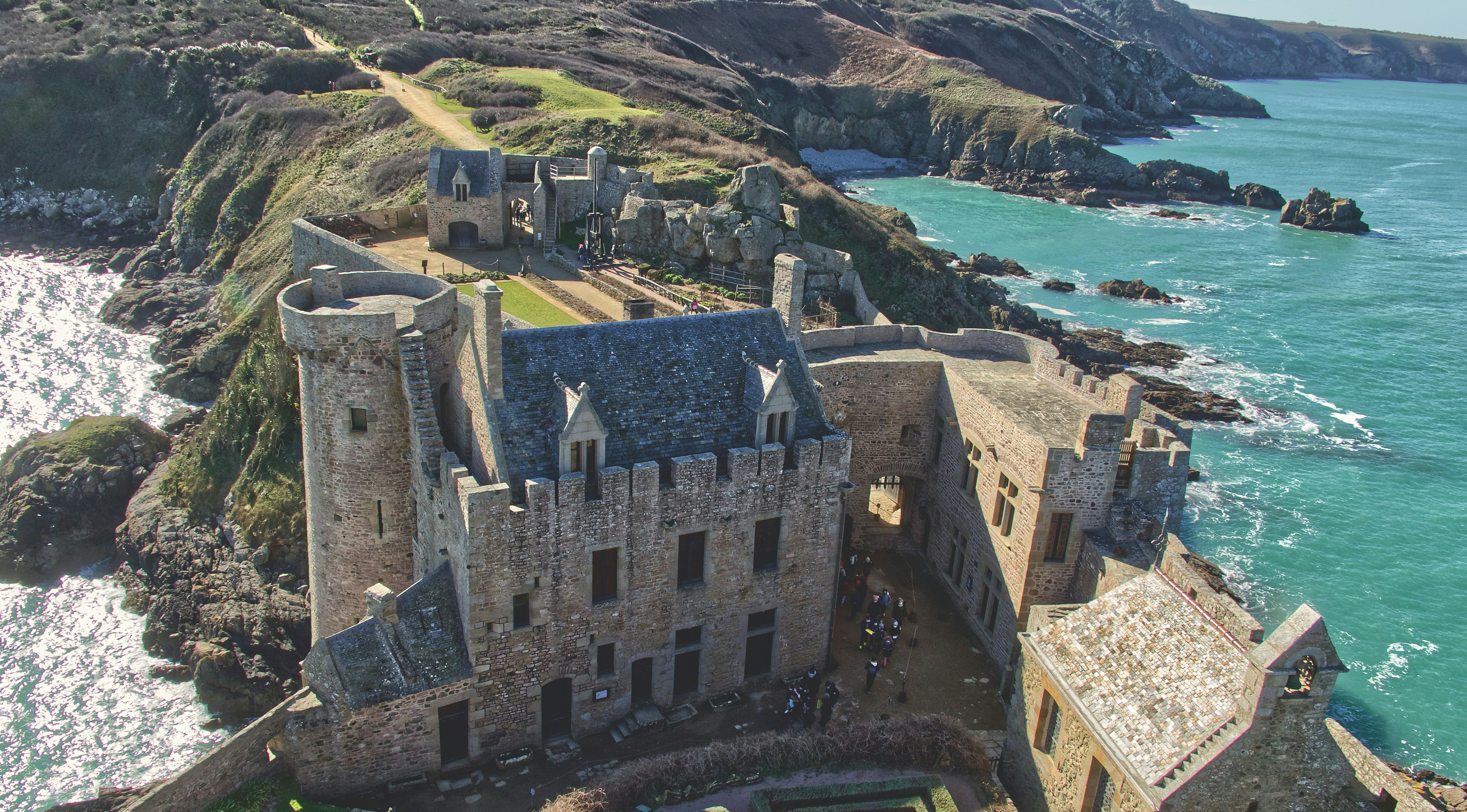 a castle on a cliff above the ocean, Vue plongeante sur l’intérieur du Fort La Latte. La vue en haut du donjon est époustouflante !.</p><p>