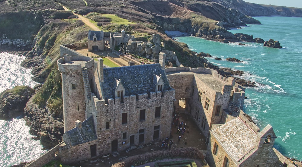 a castle on a cliff above the ocean