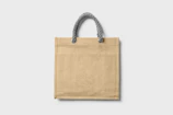 Handcrafted jute bag with natural fibers and reinforced handles.