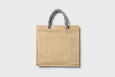 A warm, minimalistic photo of a beige tote bag made of manta fabric with subtle boho embroidery.