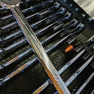 Close-up of locksmith tools neatly arranged on a wooden workbench.