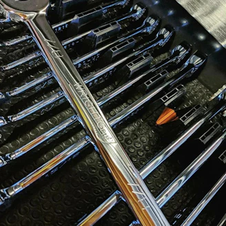 Close-up of industrial wrenches and screwdrivers neatly arranged on a workbench.