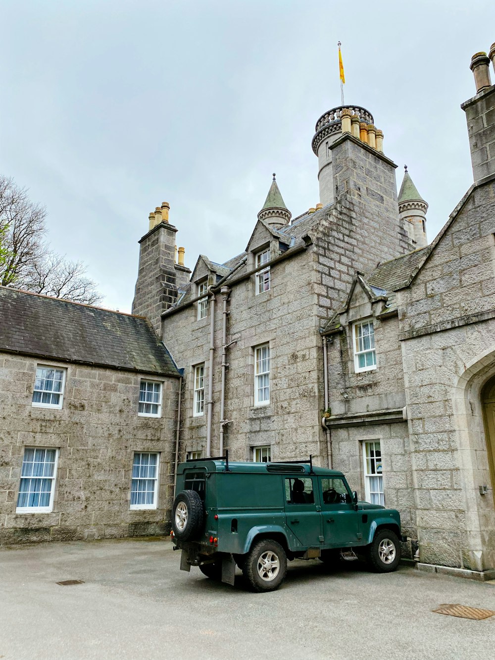 a green truck parked in front of a stone building