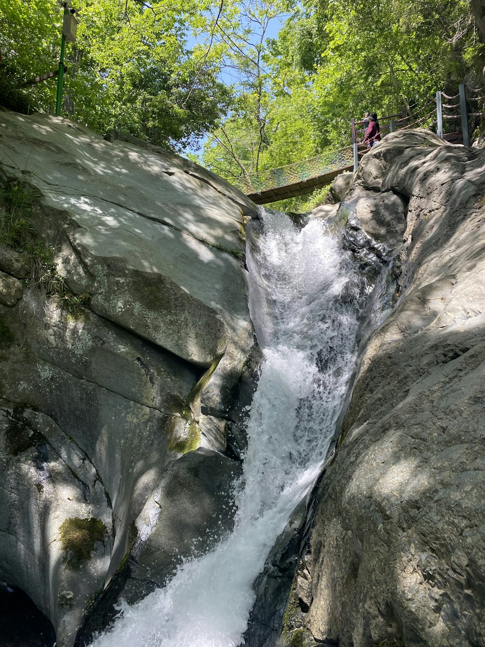 a waterfall with people walking on the side