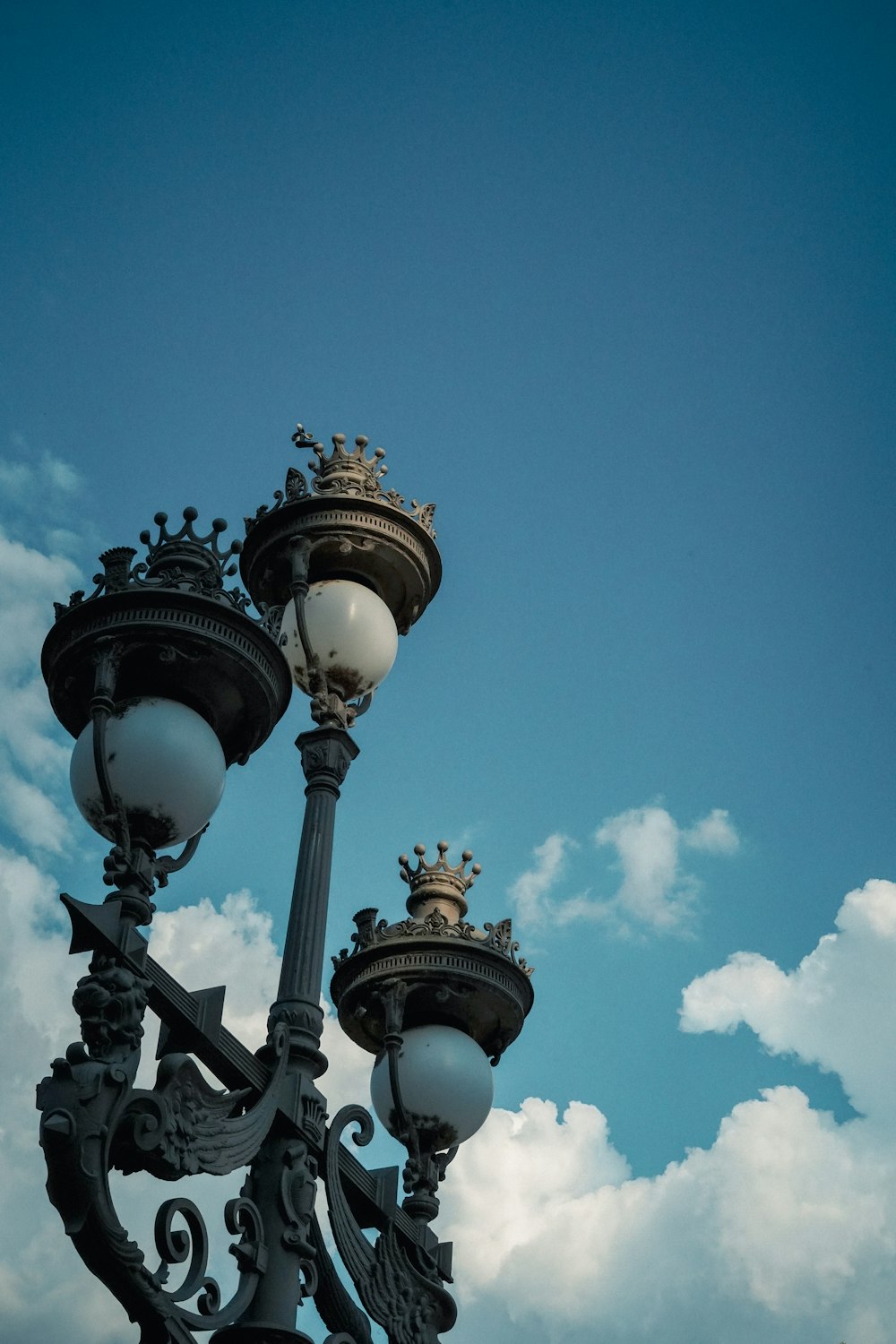 um grupo de postes de luz com um céu azul no fundo