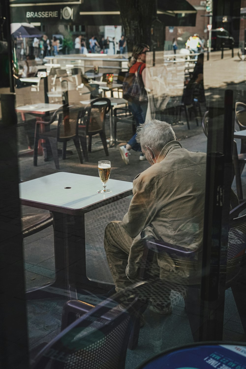 une personne assise à une table avec un verre de bière