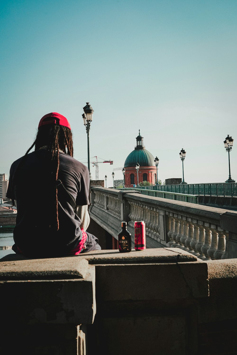 a person sitting on a ledge looking at a building