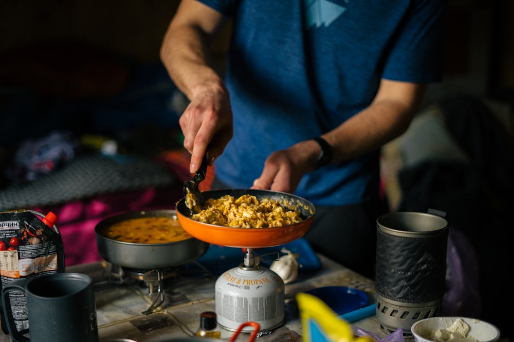 a person cooking food in a wok