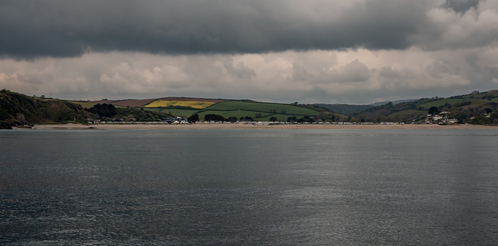 a body of water with hills in the background