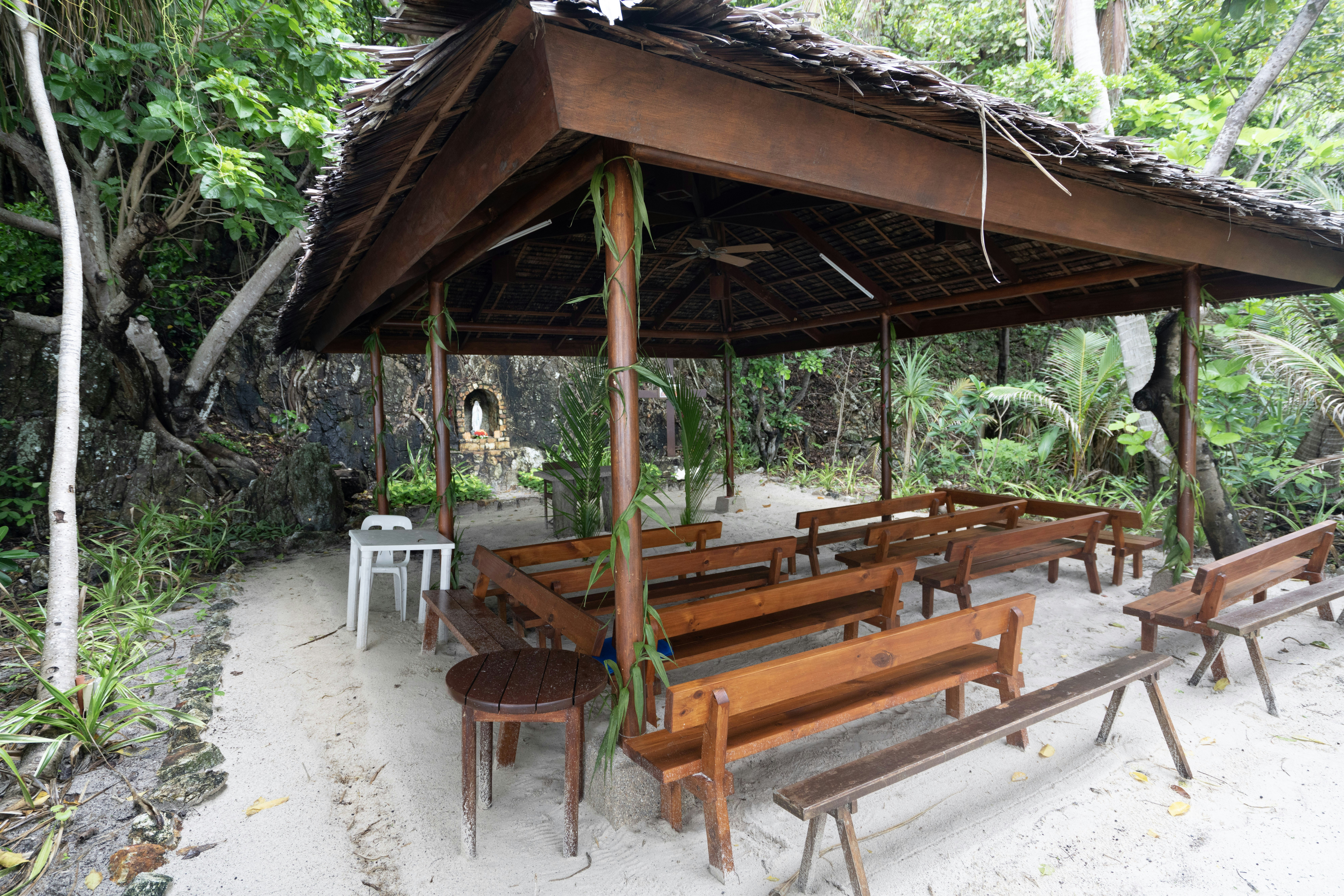 a group of wooden benches, A catholic chapel in the islands of Amanpulo in Palawan, Philippines