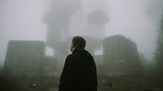 A shadowy figure resembling Milla Jovovich stands in front of a high-tech, red-lit Umbrella Corp. facility, with ominous black clouds swirling overhead.