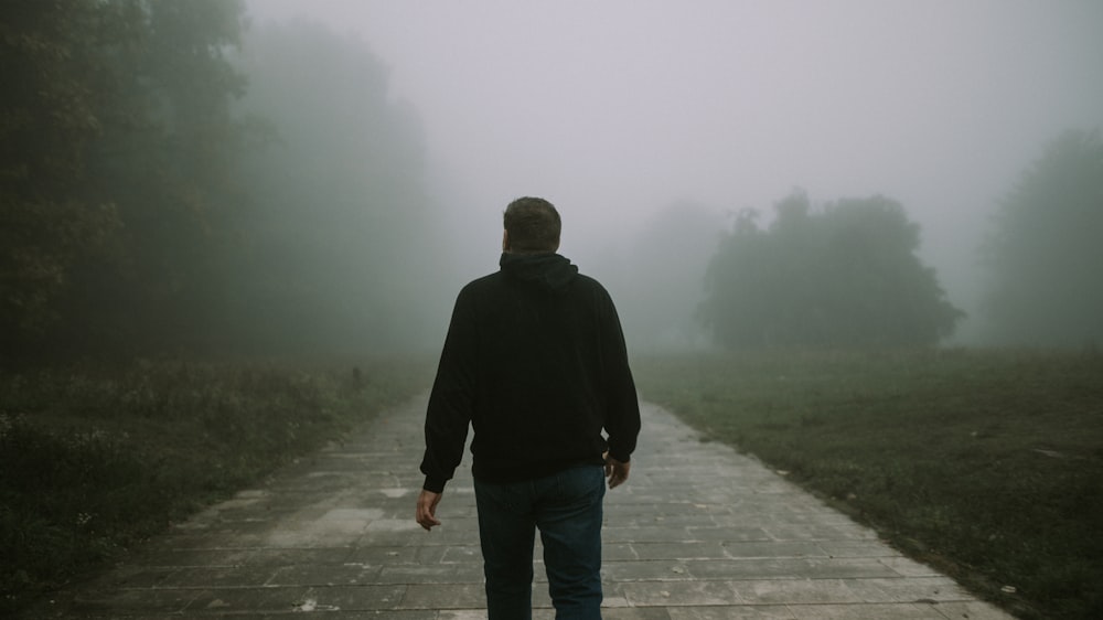 a man walking on a path in the fog