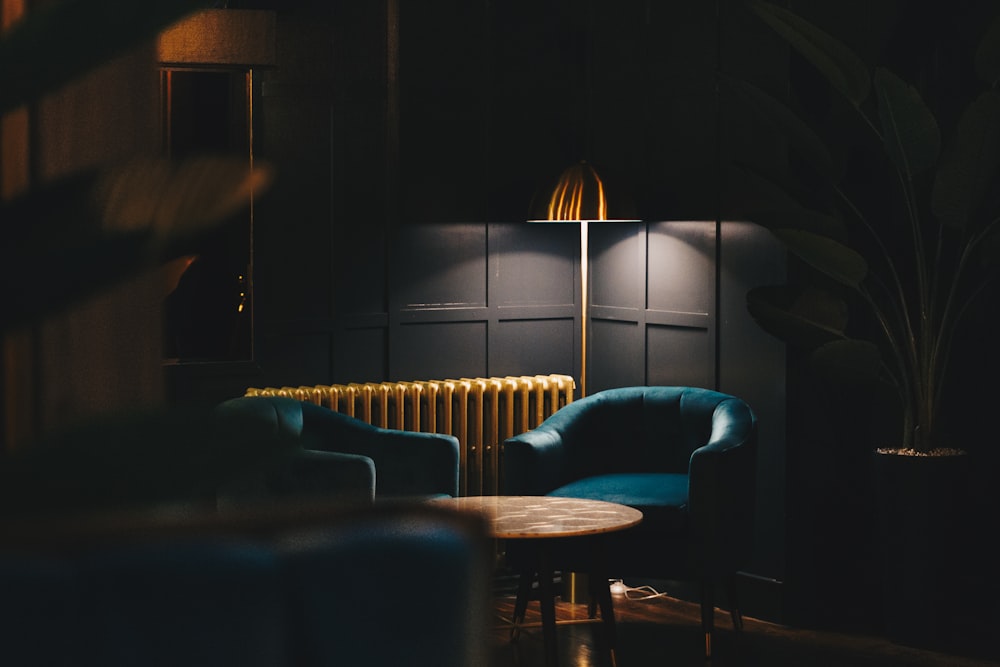 a room with a table chairs and a lamp