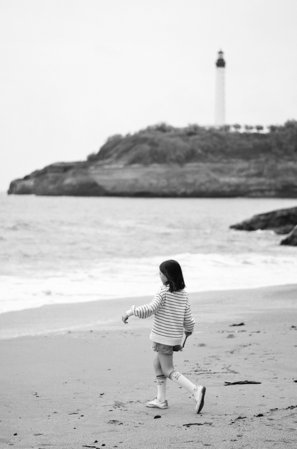 uma menina que anda em uma praia