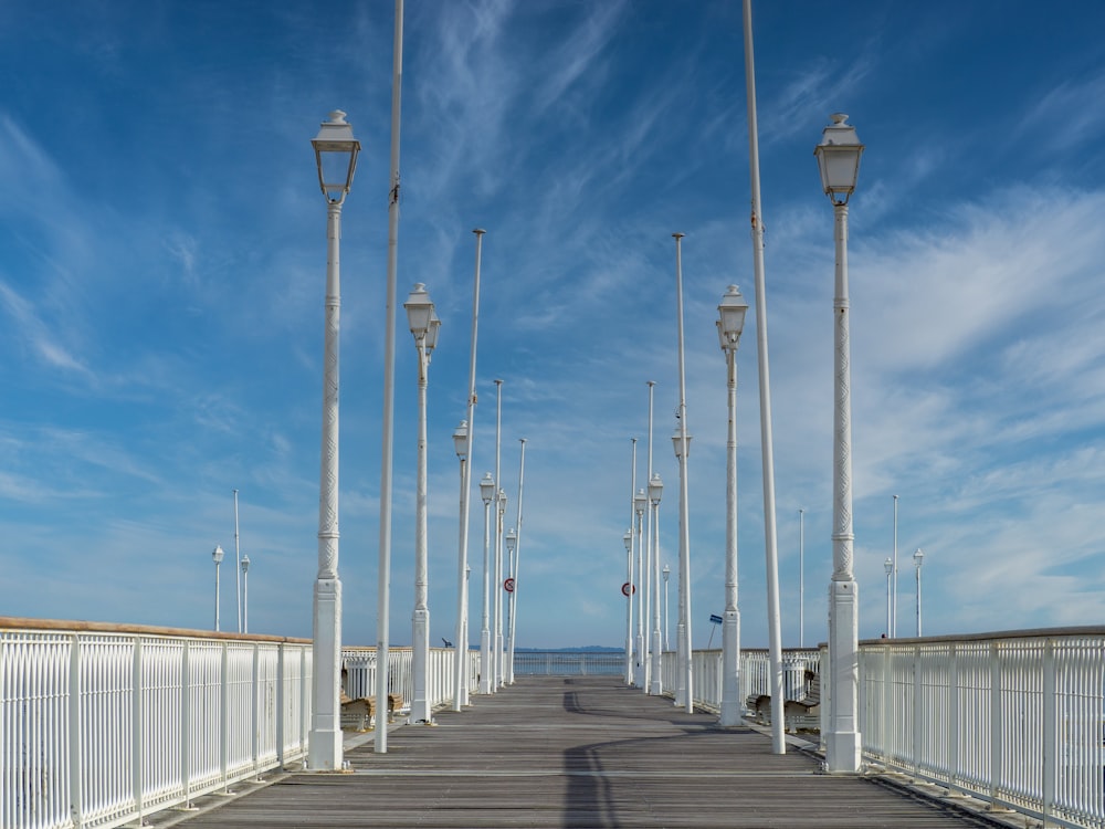 a long white bridge with white posts