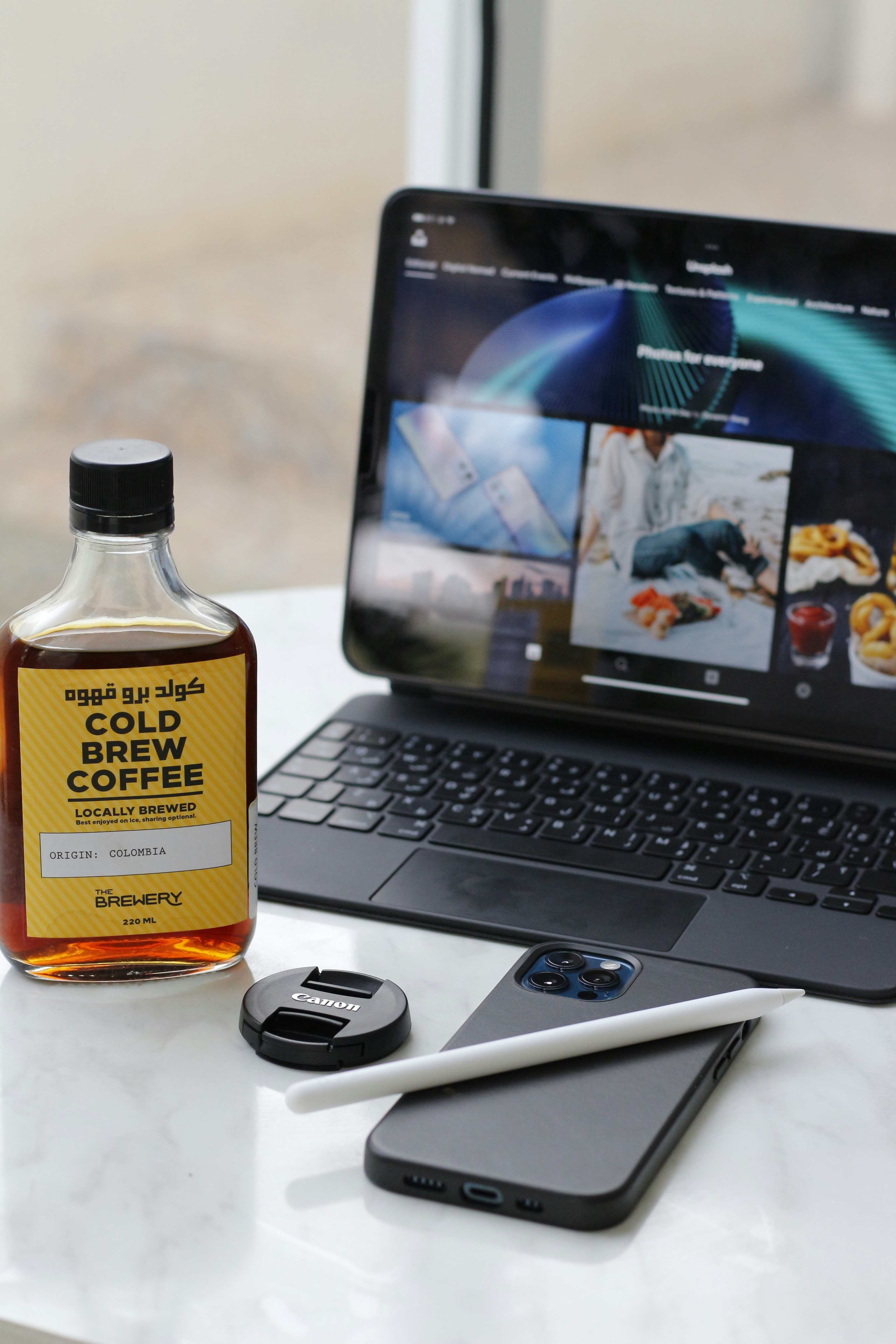 a bottle of alcohol next to a laptop
