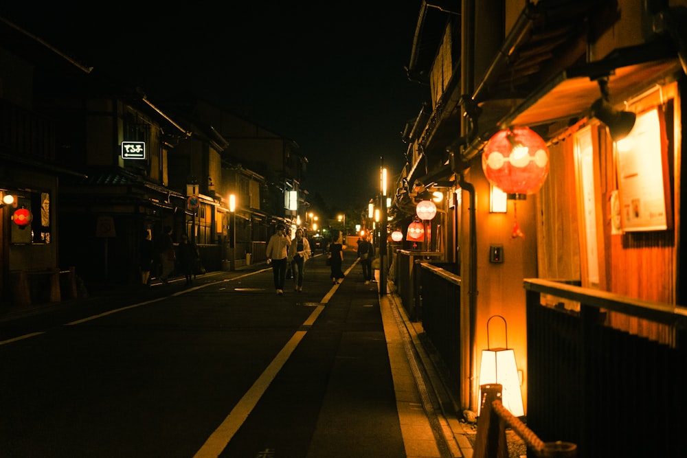 people walking down a street at night
