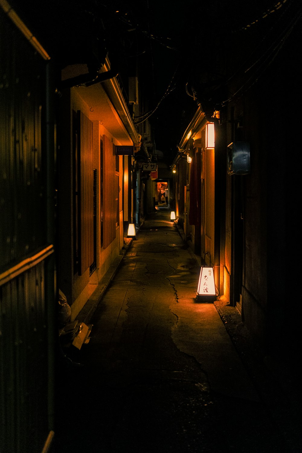 a narrow alley way with lights on