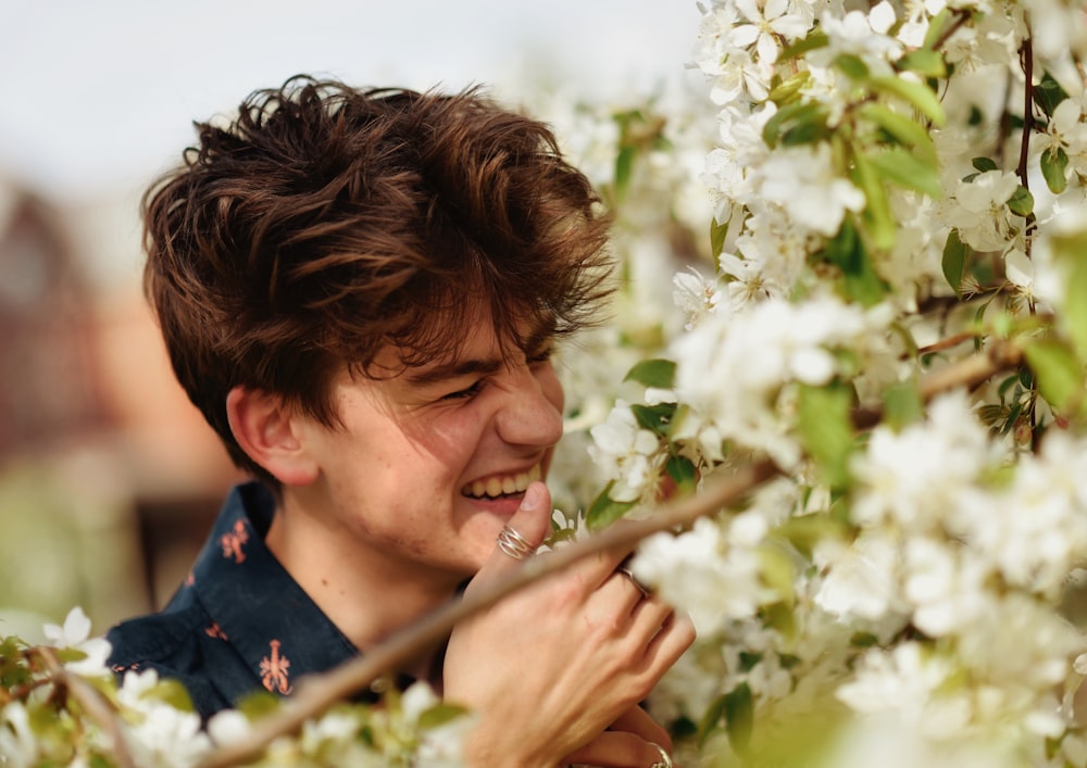 a young boy smelling a flower
