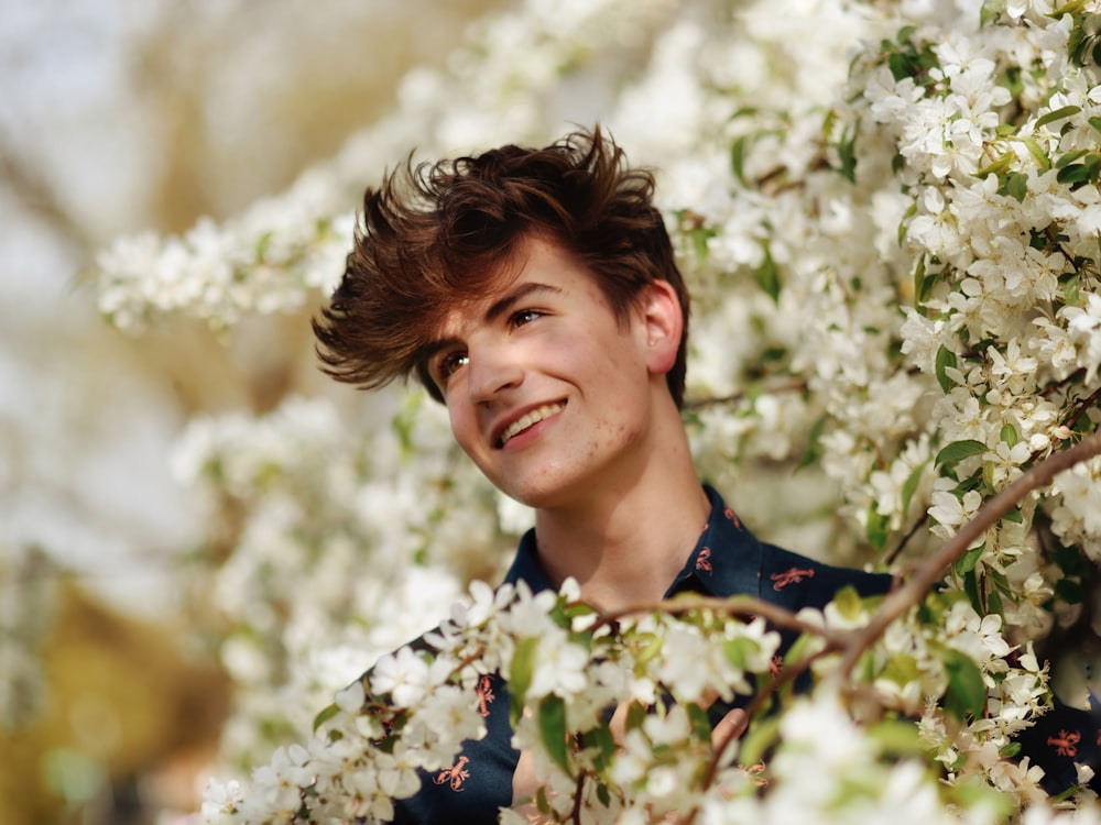 a boy smiling with a flower in his hand