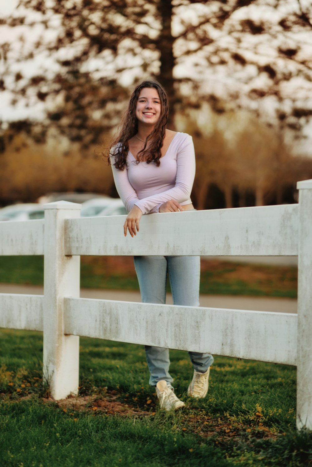 a woman standing on a white fence