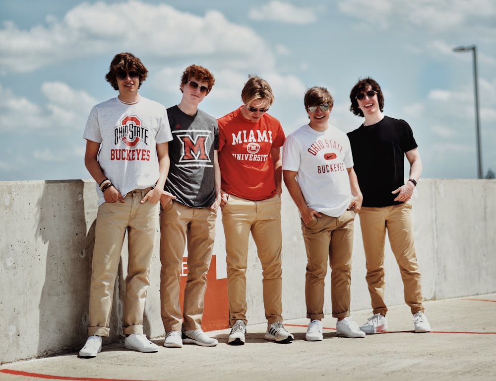 a group of men standing on a concrete wall