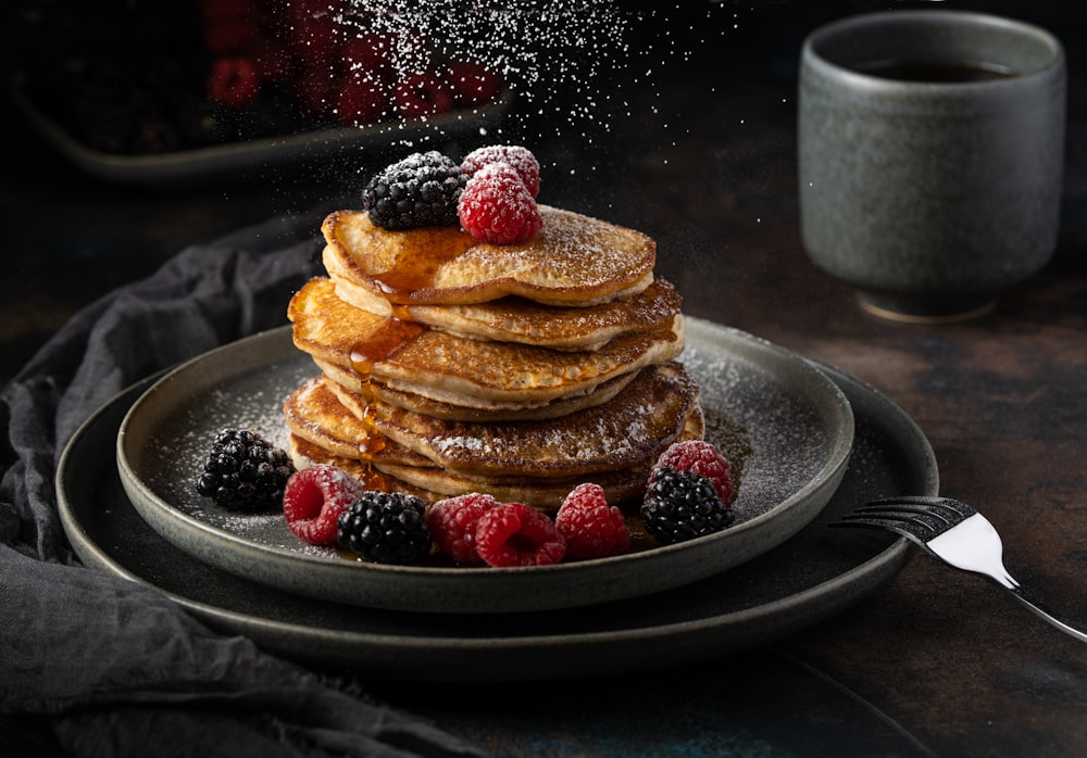 a stack of pancakes with berries on top