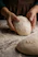 a person kneading a ball of dough on top of a table