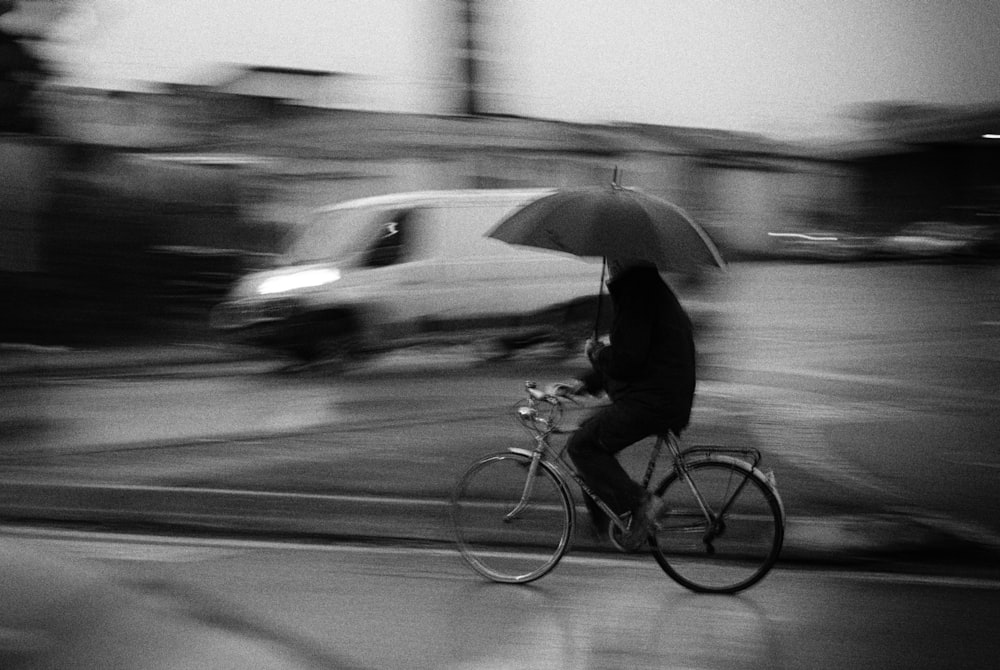 a person riding a bicycle with an umbrella