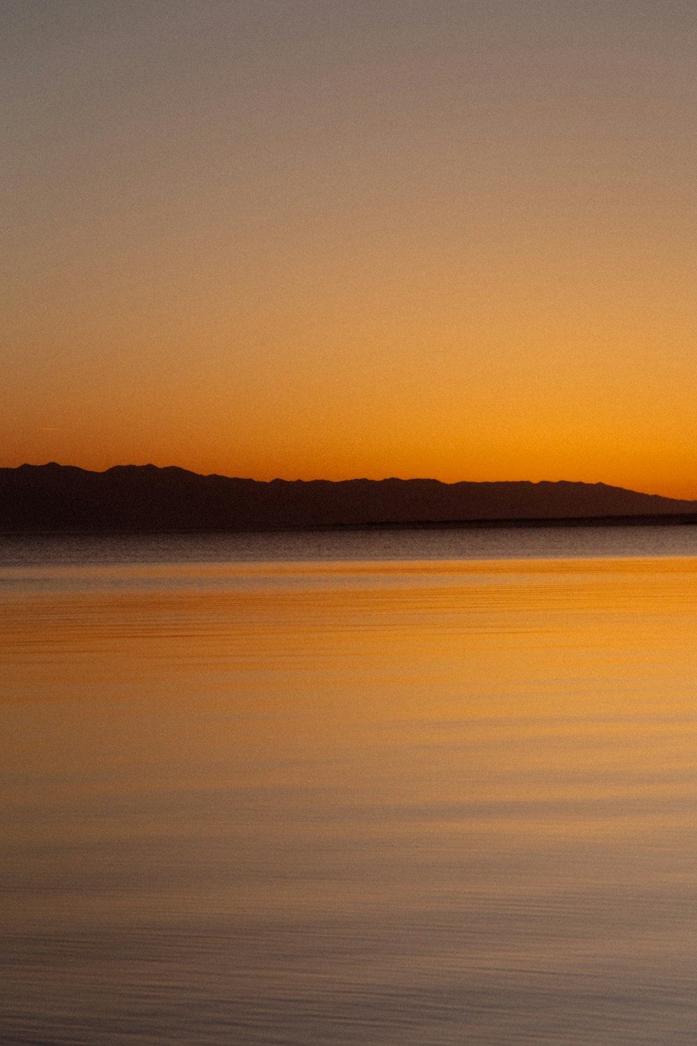 Ein Gewässer mit Hügeln im Hintergrund