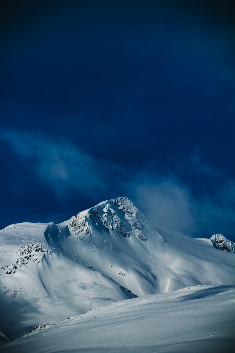 a snowy mountain with a blue sky