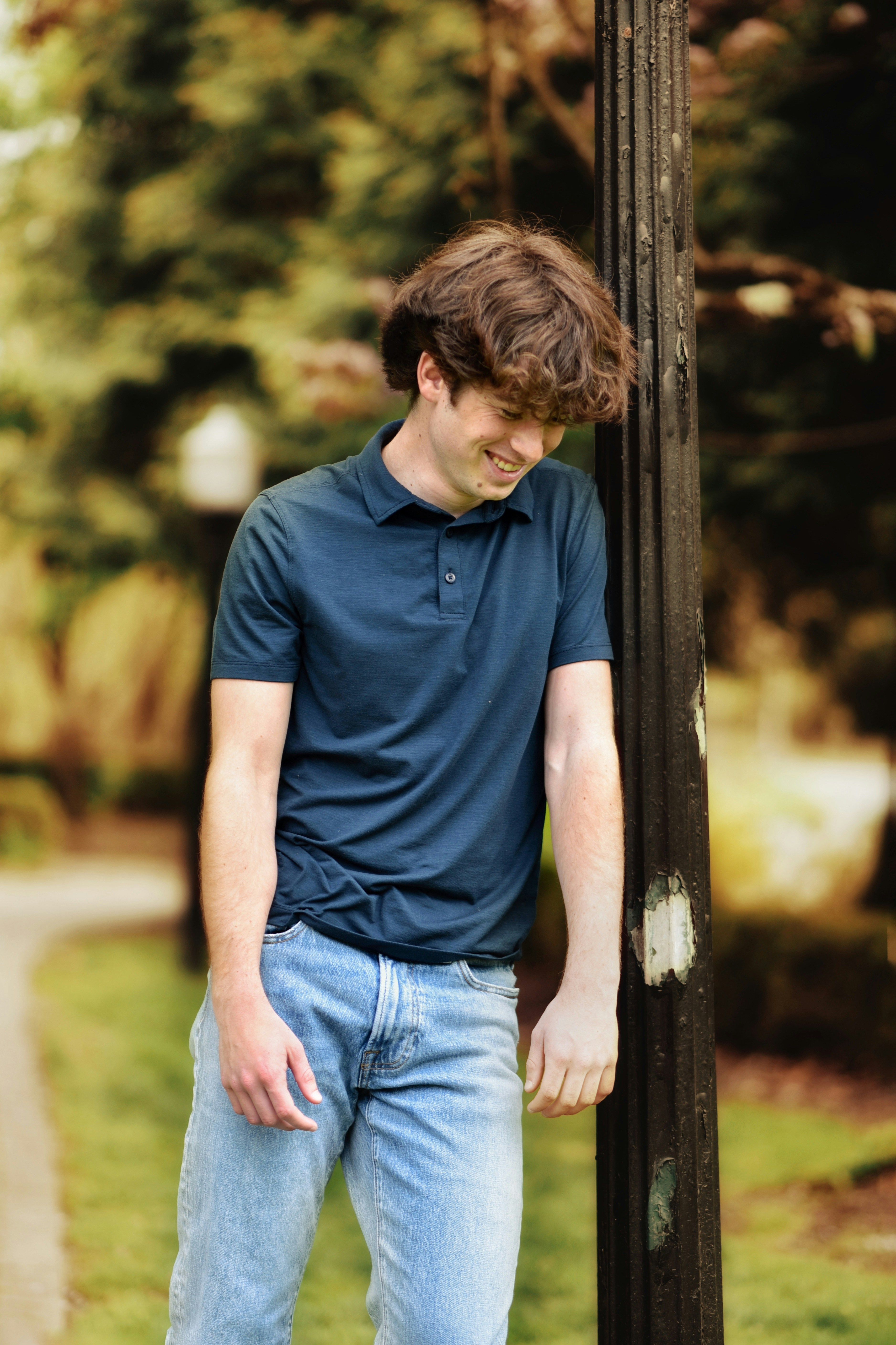 A man leaning against a pole photo – Free Woods Image on Unsplash