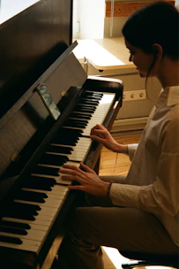 A young pianist smiling warmly during a private lesson in a sunlit, elegant studio.
