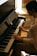 A focused young man playing piano keys in a cozy home studio setting.