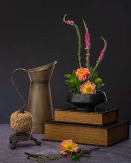 a vase with flowers and a teapot on a table