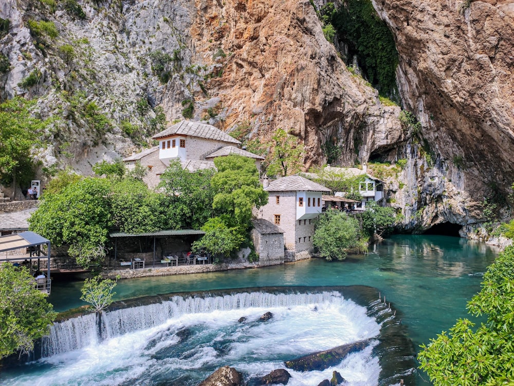 a waterfall and a building by a cliff