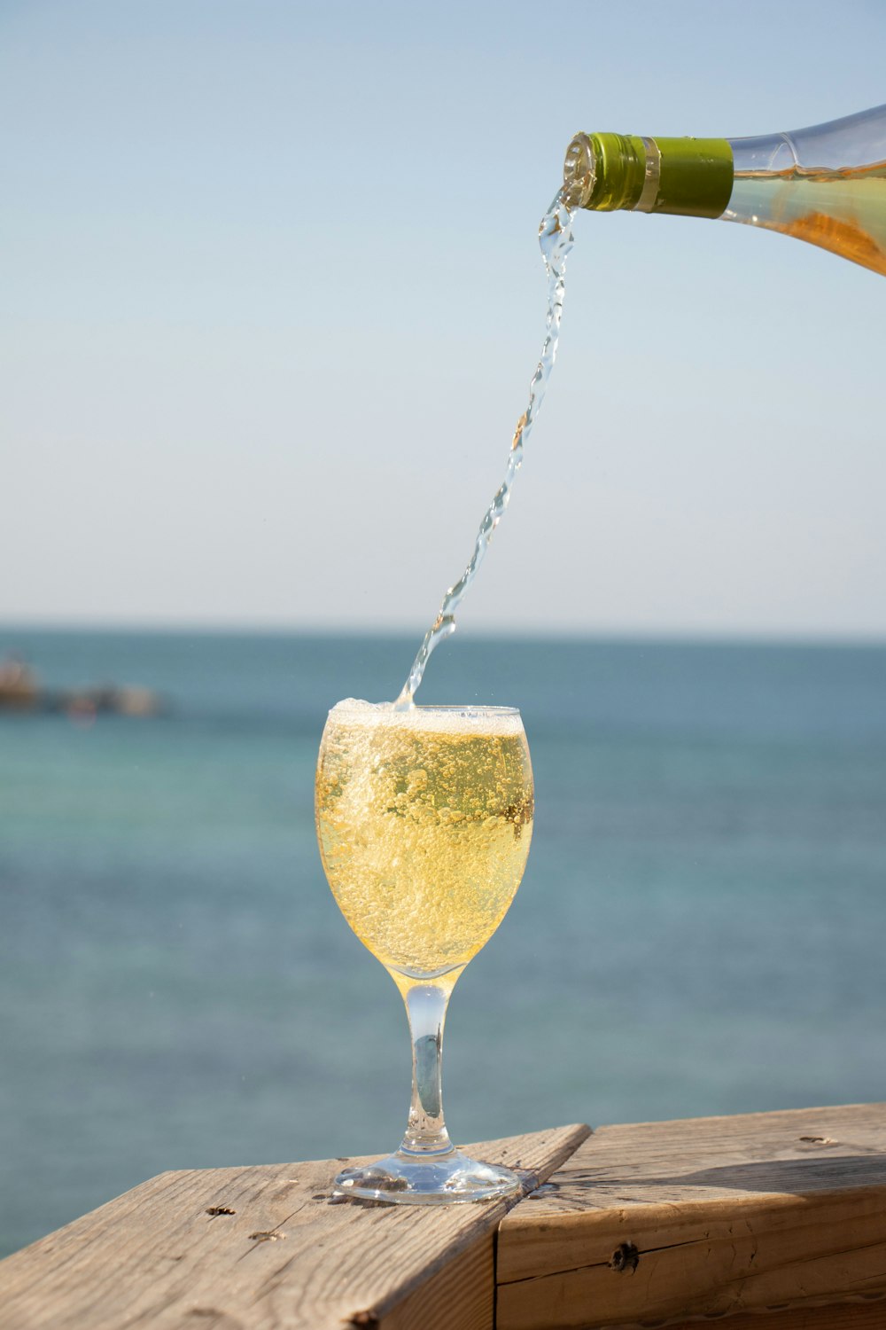 um copo de vinho com uma garrafa de champanhe em uma mesa de madeira