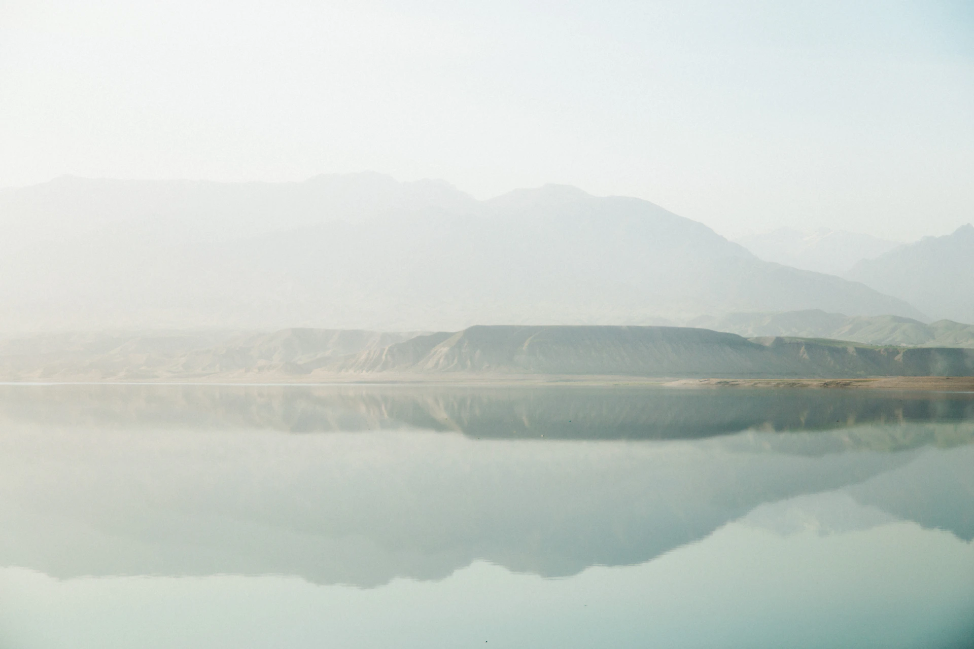a large body of water with a mountain in the background