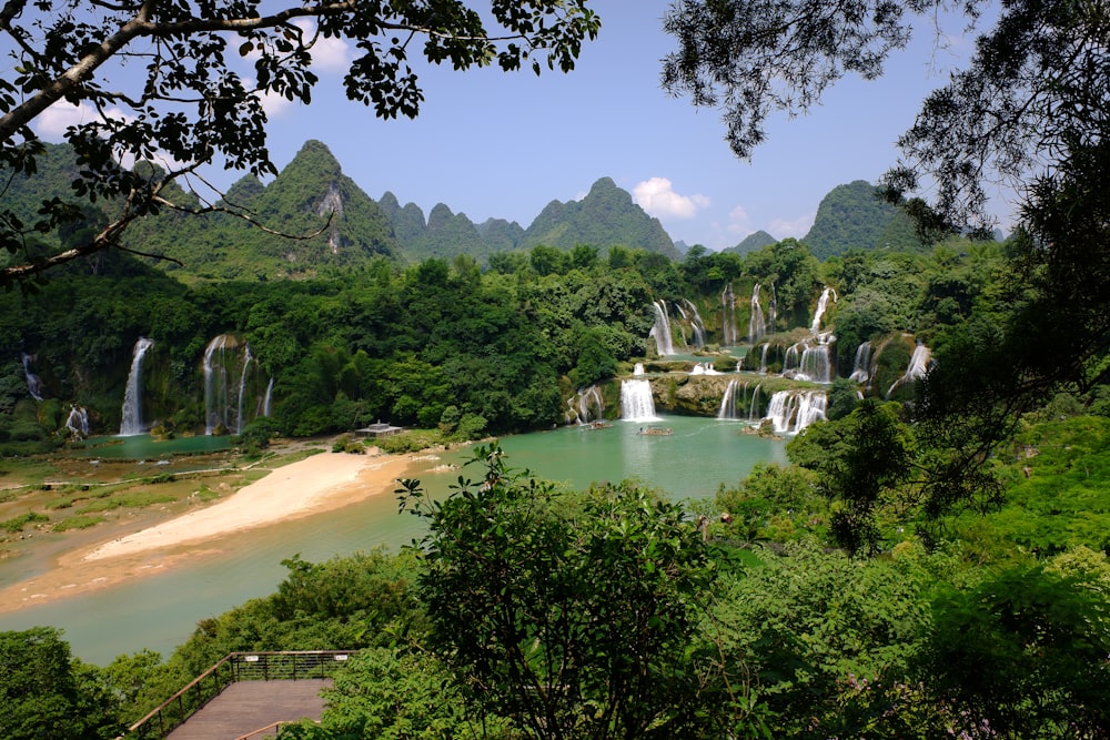 un plan d’eau avec une cascade et des arbres autour