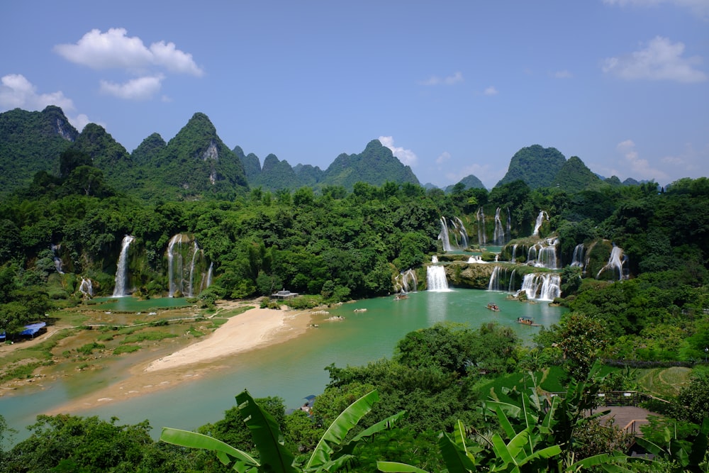 a body of water with a group of waterfalls and trees around it