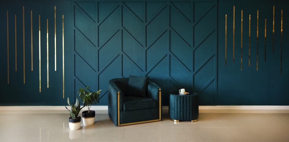 una silla de cuero negro frente a una pared azul con plantas en macetas