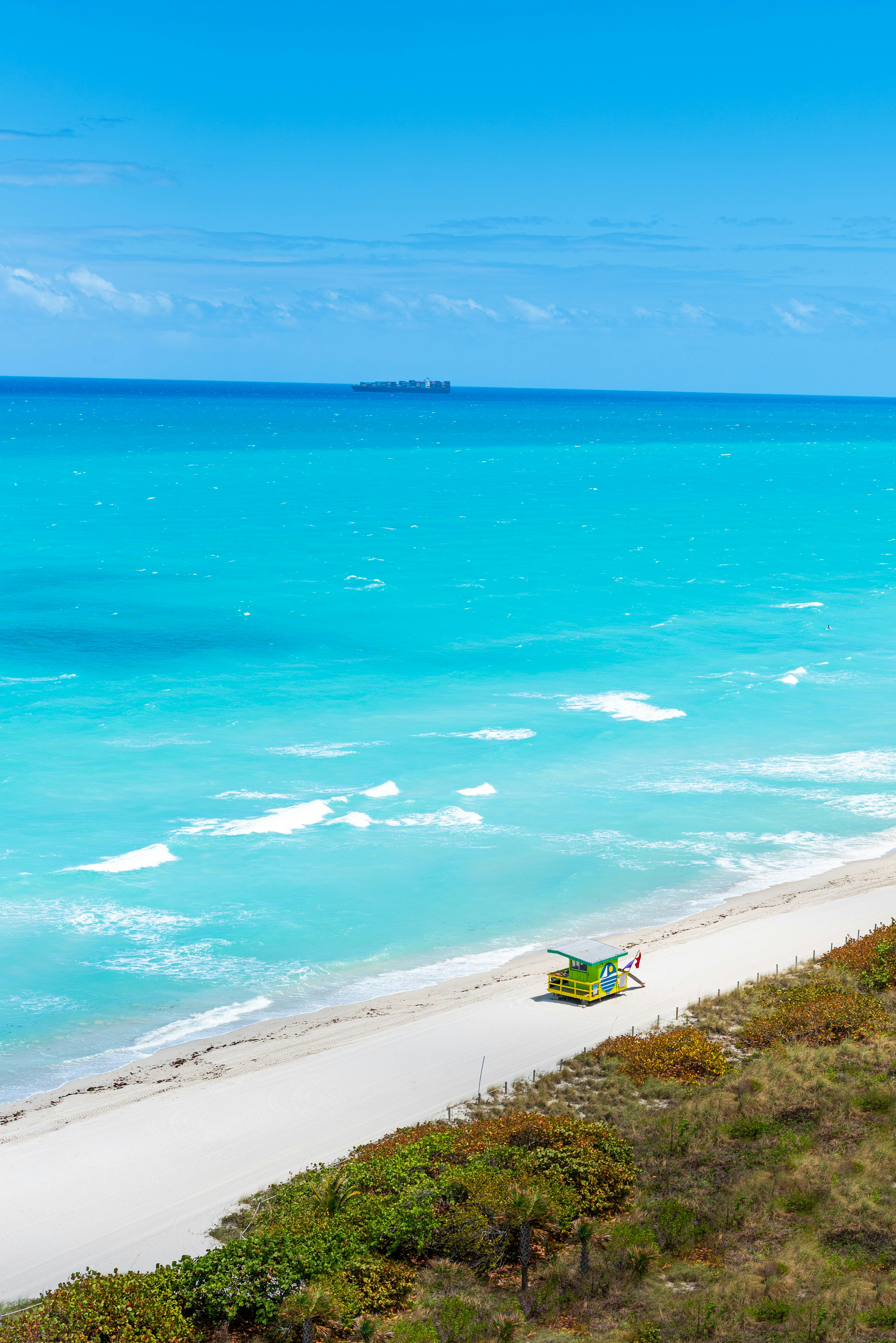 a beach with a chair and a body of water