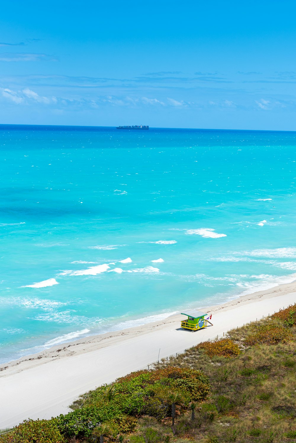 a beach with a chair and a body of water