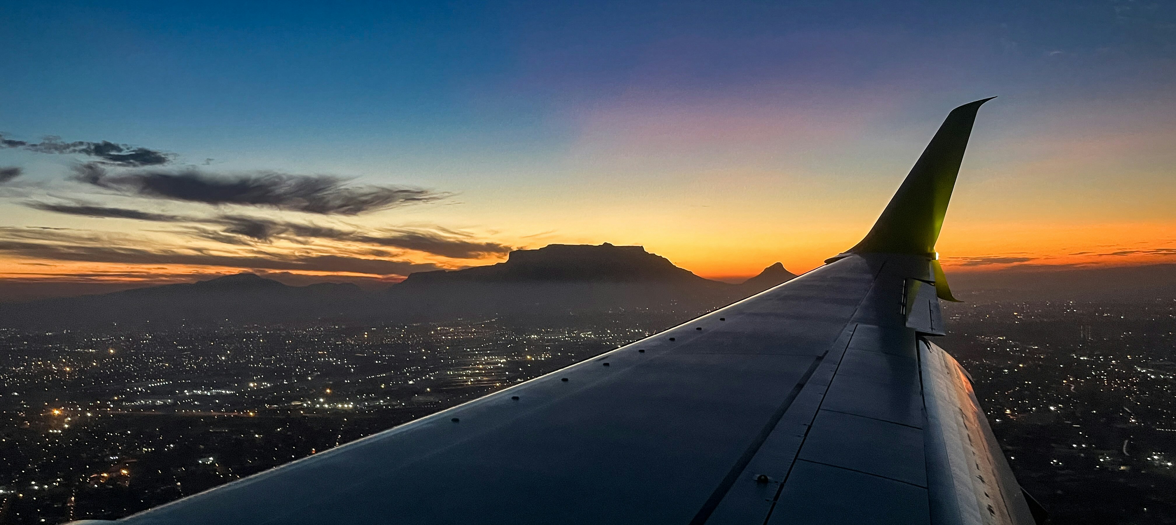 an airplane wing with a city below, 