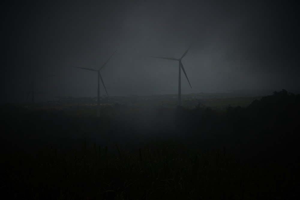 a group of wind turbines in a foggy area