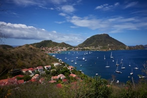 a body of water with boats in it and hills around it