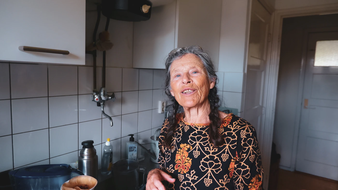 An older woman smiling in her kitchen