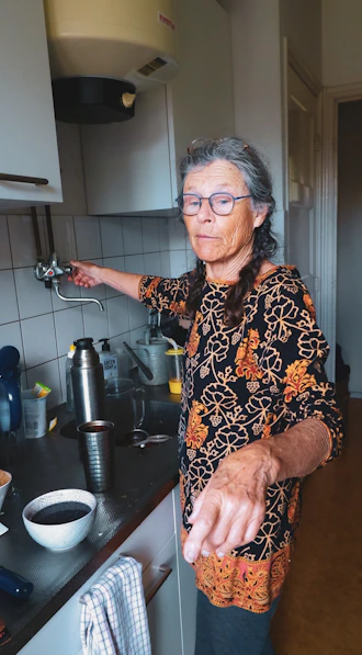 a man with tattoos in a kitchen